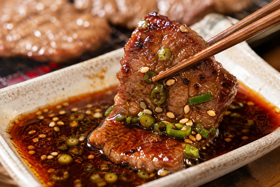 ボウルでタレに漬け込まれる焼肉用の肉と、すりおろし玉ねぎ・にんにく・ごま油などの調味料