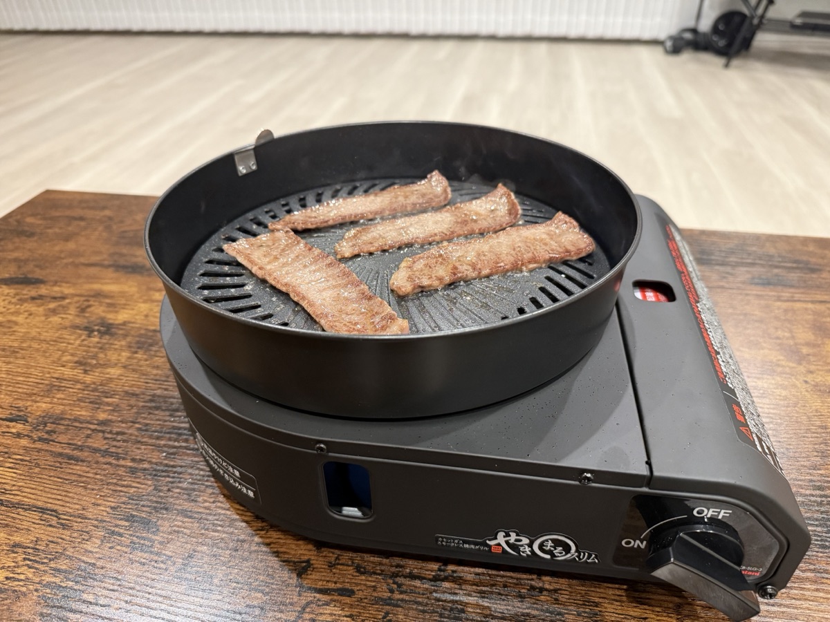持ち運べる無煙グリルで焼いた、こんがり焼き色のステーキ肉